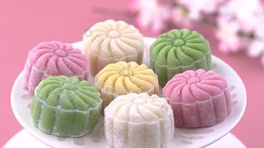 色彩斑斓的雪皮肤月亮蛋糕甜蜜的雪月饼传统的风味极佳的甜点中秋节日柔和的苍白的粉红色的背景关闭生活方式